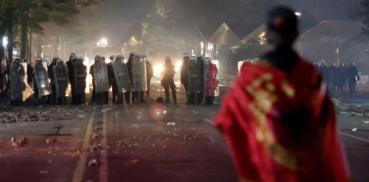 Un manifestante se encuentra frente a la policía antidisturbios durante los enfrentamientos en la plaza Skanderbeg, en el marco de una protesta en Tirana, en la que cientos de personas se congregaron para exigir la dimisión del primer ministro albanés, Edi Rama, y una mejor educación. La policía utilizó gases lacrimógenos y cañones de agua mientras los manifestantes lanzaban piedras, rompían ventanas del Ministerio de Educación, derribaban una valla e incendiaban contenedores de basura; el saldo fue de seis agentes de policía y una periodista heridos, según informaron las autoridades policiales.
