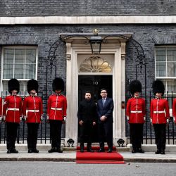 El primer ministro británico, Andy Burnham (derecha), saluda al presidente de Ucrania, Volodímir Zelenski, flanqueado por miembros de la 12.ª compañía de la Guardia Irlandesa (Irish Guards), en la escalinata del número 10 de Downing Street, en el centro de Londres, antes de su reunión. | Foto:HENRY NICHOLLS / POOL / AFP