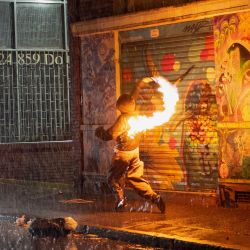 Un manifestante lanza un cóctel molotov durante enfrentamientos con la policía tras una protesta contra el presidente de Colombia, Abelardo de la Espriella, en Bogotá. Miles de colombianos salieron a las calles en ciudades de todo el país para protestar contra las políticas del nuevo presidente de derecha, Abelardo de la Espriella. | Foto:PIERRE BRIOULT / AFP