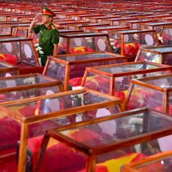 Un soldado hace el saludo militar mientras permanece de pie entre ataúdes que contienen los restos de soldados caídos, en el parque Le Thi Rieng de la ciudad de Ho Chi Minh. Vietnam celebró los ritos funerarios de más de 700 de sus caídos en combate, cuyos restos fueron exhumados en el marco de una importante iniciativa destinada a identificar a los desaparecidos durante décadas de conflicto con Francia y Estados Unidos. | Foto:NHAC NGUYEN / AFP