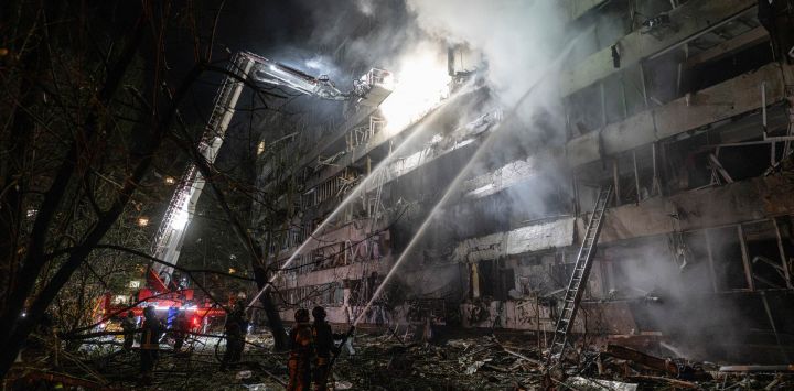 Bomberos ucranianos extinguen un incendio en el lugar donde impactó un misil ruso contra un edificio de apartamentos en Kiev, en el contexto de la invasión rusa de Ucrania.