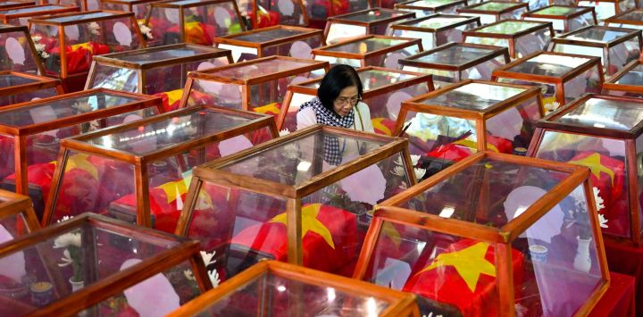 Una mujer permanece junto a ataúdes que contienen los restos de soldados caídos en el parque Le Thi Rieng, en la ciudad de Ho Chi Minh. Vietnam celebró ritos funerarios por más de 700 de sus caídos en combate, cuyos restos fueron exhumados en el marco de una importante iniciativa destinada a identificar a los desaparecidos durante décadas de conflicto con Francia y Estados Unidos.
