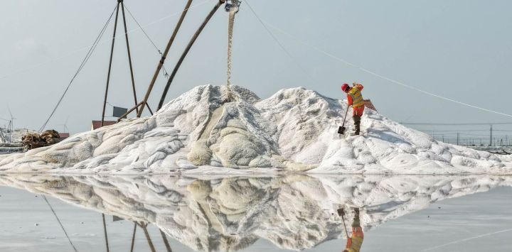 Vista aérea tomada con un dron de un trabajador operando en un campo de sal, en la ciudad de Lianyungang, en la provincia de Jiangsu, en el este de China. La cosecha de sal de otoño está en marcha en las salinas costeras de Lianyungang.
