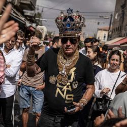 Eitan Shvili (centro), también conocido como "Rey Sharshar" y líder del partido político del mismo nombre, camina por el mercado Mahane Yehuda de Jerusalén. Israel acudirá a las urnas el 27 de octubre para celebrar sus primeras elecciones desde el ataque liderado por Hamás el 7 de octubre de 2023, en unos comicios que se perciben como un referéndum sobre la figura del primer ministro. | Foto:JOHN WESSELS / AFP