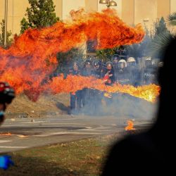 Manifestantes lanzan un cóctel molotov contra una unidad policial durante una protesta antigubernamental en el centro de Tirana, en el marco de unas movilizaciones que continúan por tercer día consecutivo debido a las condiciones en las universidades y a la exigencia de la dimisión del primer ministro albanés, Edi Rama. Esta última manifestación se produce tras dos noches de violencia en la capital, durante las cuales se registraron enfrentamientos entre manifestantes y la policía antidisturbios; las fuerzas de seguridad emplearon cañones de agua y gases lacrimógenos, mientras que los manifestantes causaron daños en oficinas gubernamentales y comercios, además de incendiar varios edificios. | Foto:Adnan Beci / AFP