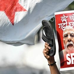 Un estudiante activista muestra un cartel del primer ministro de la India, Narendra Modi, durante una protesta en la que se exige la dimisión del comisionado jefe electoral del país, Gyanesh Kumar, debido a presuntas irregularidades en el censo electoral vinculadas a la "revisión intensiva especial" (SIR), en Nueva Delhi. | Foto:ARUN SANKAR / AFP