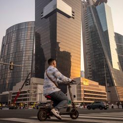 Una persona se desplaza en un monopatin eléctrico por una calle del centro de Dubái. | Foto:FADEL SENNA / AFP