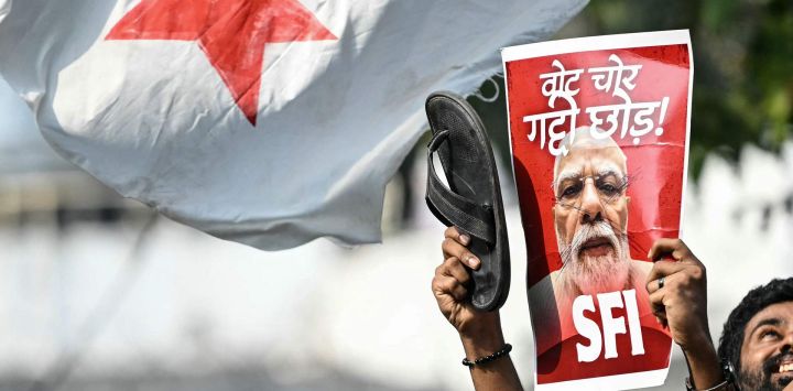 Un estudiante activista muestra un cartel del primer ministro de la India, Narendra Modi, durante una protesta en la que se exige la dimisión del comisionado jefe electoral del país, Gyanesh Kumar, debido a presuntas irregularidades en el censo electoral vinculadas a la "revisión intensiva especial" (SIR), en Nueva Delhi.