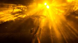 Una mujer que sostiene un paraguas posa para una fotografía mientras visita el Festival Internacional de la Luz de Shanghái, en un parque de la ciudad.
