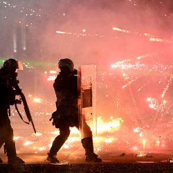 Agentes de la policía antidisturbios se ponen a cubierto mientras los manifestantes lanzan un cóctel molotov durante una protesta antigubernamental en el centro de Tirana; las manifestaciones continuaron por sexto día consecutivo debido a las condiciones en las universidades y a la exigencia de la dimisión del primer ministro de Albania. La policía albanesa empleó cañones de agua y gases lacrimógenos en el sexto día de violentas protestas antigubernamentales, mientras el primer ministro rechazaba la exigencia de los manifestantes de que renunciara a su cargo. | Foto:Armend Nimani / AFP