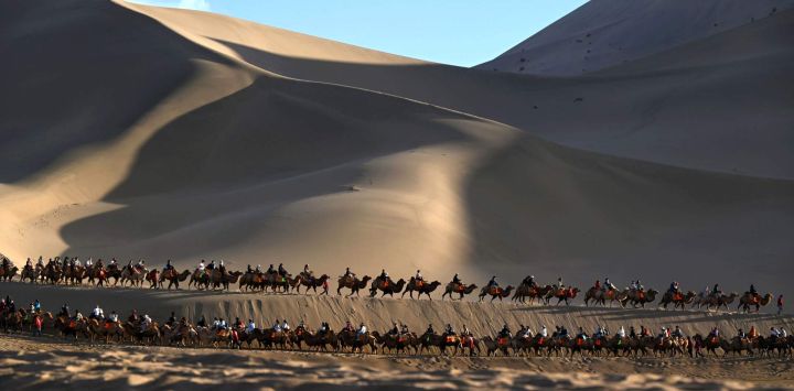 Imagen de turistas montando camellos en el área escénica de la Montaña Mingsha y el Manantial de la Luna Creciente, en Dunhuang, en la provincia de Gansu, en el noroeste de China. En promedio diario, el número de viajes dentro del territorio nacional aumentó un 6,3 por ciento en comparación con los ocho días de la temporada vacacional con motivo del Día Nacional y el Festival del Medio Otoño de 2025, mientras que el gasto en turismo creció un 4,3 por ciento, según el Ministerio de Cultura y Turismo.