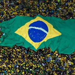 Esta vista aérea muestra a partidarios del senador brasileño de derecha y candidato presidencial del Partido Liberal (PL), Flavio Bolsonaro, sosteniendo una bandera brasileña gigante durante un mitin en la Avenida Paulista, en São Paulo, Brasil, antes de la segunda vuelta de las elecciones presidenciales. | Foto:MIGUEL SCHINCARIOL / AFP
