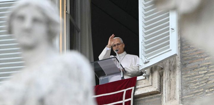 El Papa León XIV bendice a la multitud desde la ventana del palacio apostólico que da a la plaza de San Pedro, durante el rezo del Ángelus, un día después de su regreso al Vaticano tras una intervención quirúrgica para extirpar un tumor canceroso en su pulmón derecho.