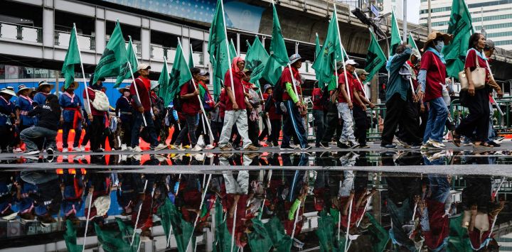 Manifestantes marchan bajo una pasarela durante una protesta contra el Fondo Monetario Internacional (FMI) y el Grupo del Banco Mundial en Bangkok, mientras se celebran las reuniones anuales del FMI en la capital tailandesa.