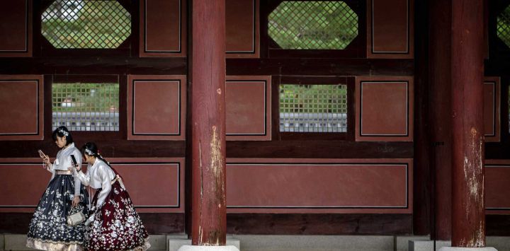 Turistas con trajes tradicionales hanbok visitan el palacio Gyeongbokgung en Seúl, Corea del Sur.