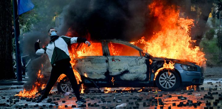 Un manifestante lanza un adoquín durante una protesta antigubernamental en el centro de Tirana, en el quinto día consecutivo de movilizaciones motivadas por las condiciones en las universidades y la exigencia de dimisión del primer ministro albanés. Varios cientos de personas, algunas de ellas con el rostro cubierto, se congregaron hacia el mediodía frente al Ministerio de Educación; posteriormente, las protestas se extendieron por toda la ciudad. Los manifestantes lanzaron piedras contra la policía y prendieron fuego a contenedores de basura, utilizándolos como barricadas para impedir el avance de los agentes.