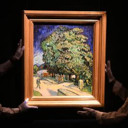 Personal de Sotheby's manipula el cuadro "Châtaigniers en fleurs" (Castaños en flor), de Vincent van Gogh, durante una presentación previa a una subasta en Hong Kong. La obra, pintada en Auvers-sur-Oise durante los últimos meses de vida del artista, será subastada en Nueva York en noviembre de 2026, con un precio estimado en torno a los 180 millones de dólares estadounidenses. | Foto:PETER PARKS / AFP