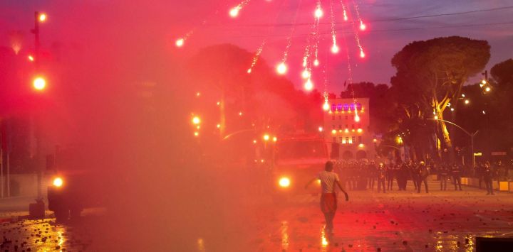 Manifestantes lanzan fuegos artificiales contra la policía antidisturbios durante una protesta antigubernamental en el centro de Tirana, en el marco de unas movilizaciones que continúan por tercer día consecutivo debido a las condiciones en las universidades y a la exigencia de la dimisión del primer ministro albanés, Edi Rama.