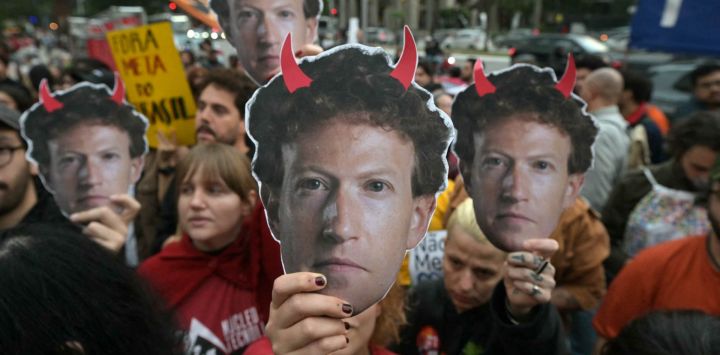 Partidarios del presidente de Brasil y candidato presidencial Luiz Inácio Lula da Silva sostienen máscaras que representan al director ejecutivo de Meta, Mark Zuckerberg, con cuernos rojos, durante una manifestación frente a la sede de Meta en São Paulo, Brasil, para denunciar una presunta injerencia de las grandes empresas tecnológicas en las elecciones brasileñas.
