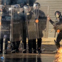 Agentes de la policía antidisturbios de Albania hacen gestos durante una manifestación antigubernamental en el centro de Tirana, tras una semana de violentas protestas contra el gobierno. El primer ministro albanés atribuyó la inestabilidad en su país a una "guerra híbrida", después de una semana de violentas manifestaciones antigubernamentales en Tirana. Los manifestantes se han enfrentado en repetidas ocasiones a la policía a medida que se intensifican meses de protestas, impulsadas por nuevas exigencias de mejores condiciones universitarias, el descontento ante la corrupción y renovadas peticiones de dimisión del primer ministro. | Foto:Adnan Beci / AFP