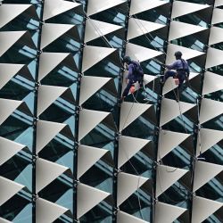 Unos trabajadores limpian la cúpula del teatro Esplanade, en Singapur. | Foto:Roslan Rahman / AFP