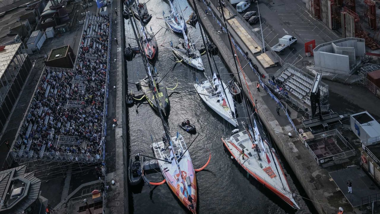 Esta fotografía aérea muestra a monocascos de la clase Imoca en el puerto de Saint-Malo, en el noroeste de Francia, pocos días antes del inicio de la regata en solitario "Route du Rhum", que parte de Saint-Malo con destino a Pointe-à-Pitre, en la isla francesa de Guadalupe. | Foto:LOU BENOIST / AFP