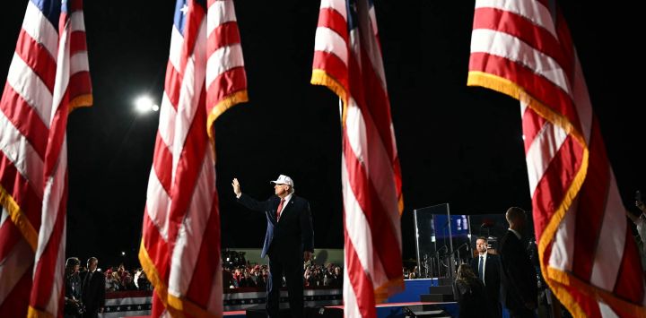 El presidente de EE. UU., Donald Trump, saluda con la mano mientras abandona el escenario tras intervenir en un mitin de campaña para las elecciones de mitad de mandato en el aeropuerto Pitt-Greenville, en Greenville, Carolina del Norte.