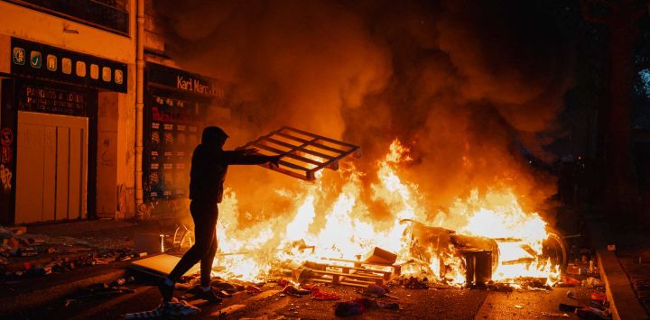 Un manifestante alimenta un fuego con diversos materiales junto al Canal Saint-Martin, en el marco de las protestas contra el "alto costo de la vida" que tienen lugar en París. La movilización, convocada a nivel nacional, reúne a diversos colectivos que expresan su descontento: antiguos "chalecos amarillos", estudiantes de secundaria y universitarios, activistas climáticos e incluso agricultores.