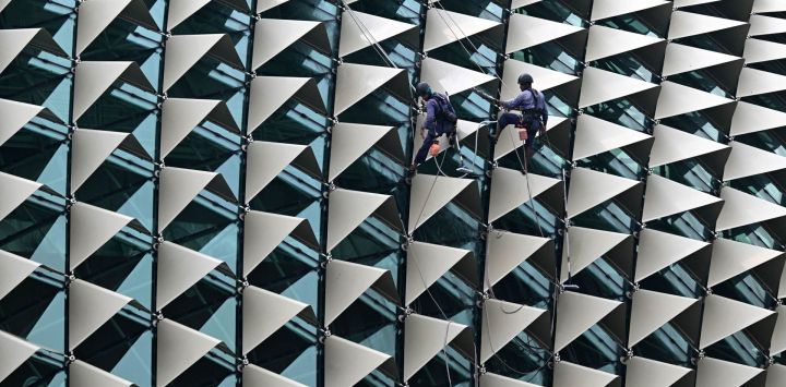 Unos trabajadores limpian la cúpula del teatro Esplanade, en Singapur.