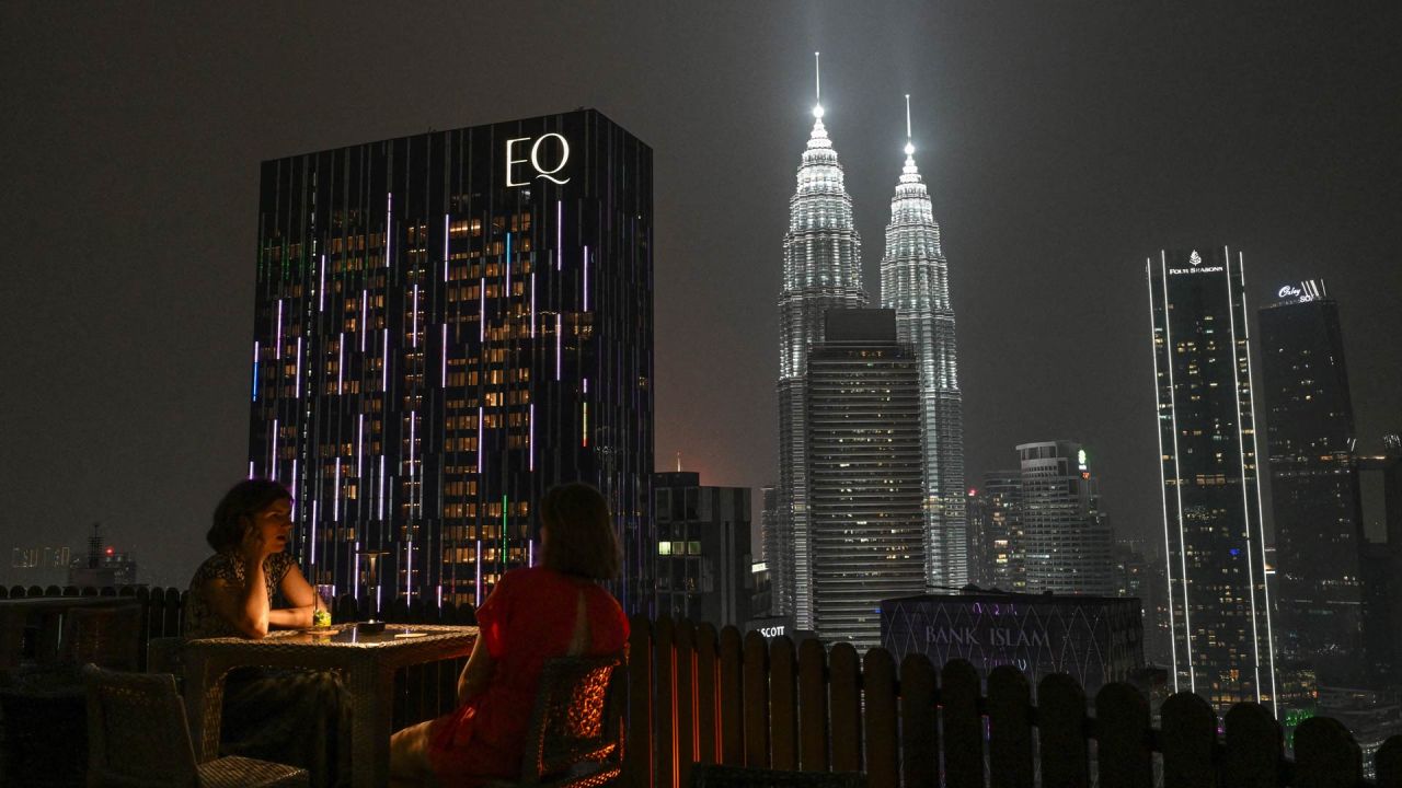 Unas mujeres están sentadas en un bar en una azotea frente a las Torres Gemelas Petronas en Kuala Lumpur, mientras el país sigue envuelto en una bruma causada por incendios en Indonesia. | Foto:JAM STA ROSA / AFP