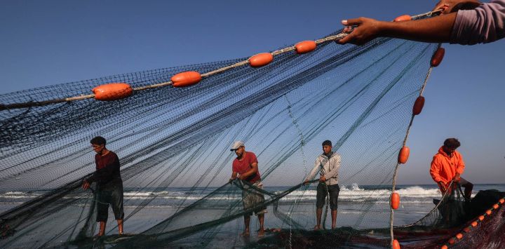 Pescadores palestinos extienden sus redes en la playa, en el campo de refugiados de Nuseirat, en la zona central de la Franja de Gaza.