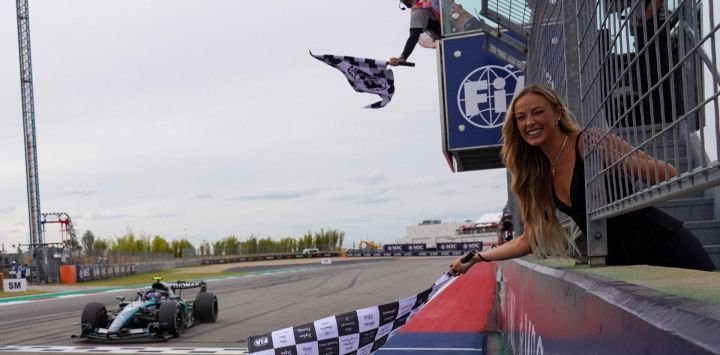Sophie Cunningham, escolta de las Indiana Fever de la WNBA, ondea la bandera a cuadros para el piloto italiano de Mercedes, Kimi Antonelli, tras su victoria en el Gran Premio de Estados Unidos de Fórmula 1, celebrado en el Circuito de las Américas en Austin, Texas.