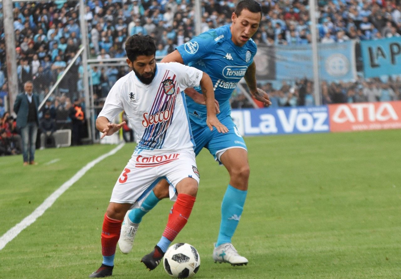 Defensor y goleador. Cristian Lema persigue a Lucas Wilchez. En el área rival, el zaguero de Belgrano fue determinante.